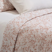 Close-up of Marjolaine quilt featuring delicate terracotta leaf print on white 100% cotton shell – available in Twin, Double-Queen, King, and Super King